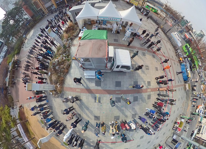 This photo taken with a 360-degree camera shows people standing in line to receive coronavirus tests at a makeshift clinic in front of a train station in Seoul on March 19, 2021. (Yonhap)