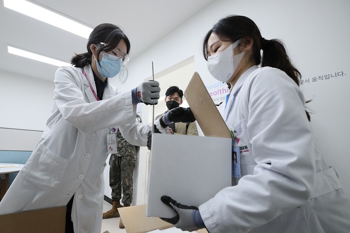 This photo taken on March 24, 2021, shows pharmacists receiving Pfizer vaccines at the National Medical Center in central Seoul. (Yonhap)