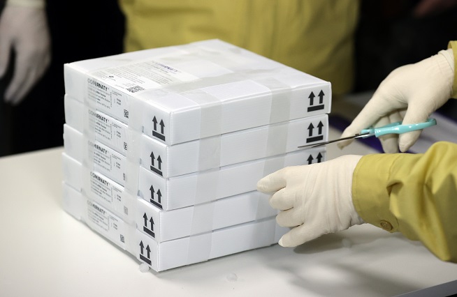 A medical official opens boxes containing the Pfizer COVID-19 vaccine at an inoculation center in Seongdong, eastern Seoul. (Yonhap)
