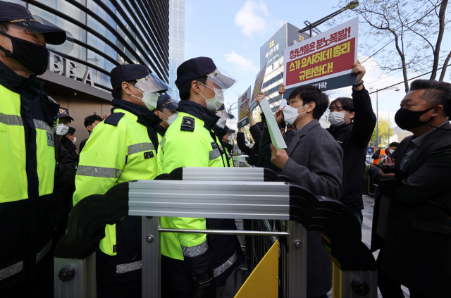 South Korean civic activists try to deliver a letter of protest against Japan's decision to release radioactive Fukushima water into the sea toward the entrance of a building housing the Japanese Embassy in downtown Seoul on April 13, 2021. (Yonhap)