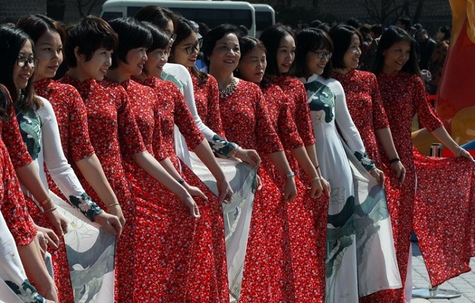 A group of Vietnamese tourists dressed in indigenous "ao dai" gowns poses for a photo in front of the presidential office in Seoul on April 3, 2019. (Yonhap)