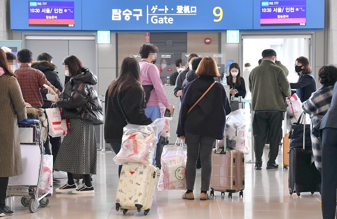 Passengers for low-cost carrier Air Seoul’s flight to nowhere stand in line in front of a departure gate at Incheon International Airport, west of Seoul, on Feb. 21, 2021. (Yonhap)