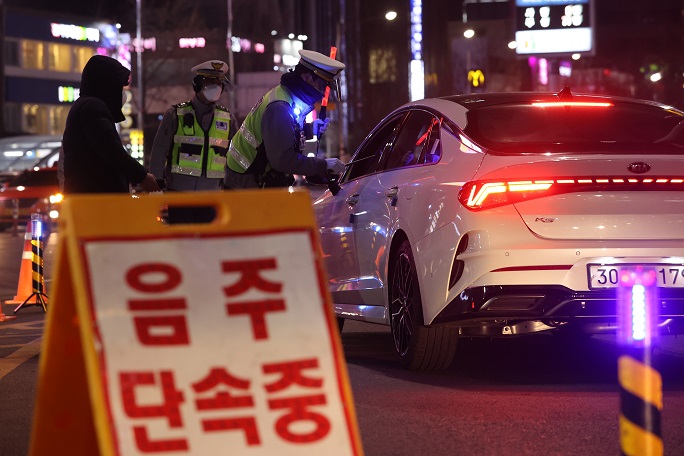 This Feb. 23, 2021, file photo shows police officers conducting a DUI checkpoint on a road in southern Seoul. (Yonhap)