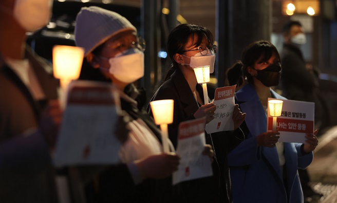 Activists hold a vigil calling for drastic measures in response to suspicious land deals involving employees of the state-run Korea Land and Housing Corp. (LH) outside its office in southern Seoul on March 15, 2021. (Yonhap)