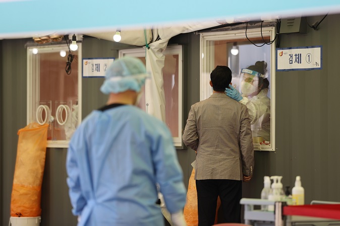 Visitors receive COVID-19 tests at a makeshift clinic in central Seoul on April 9, 2021. (Yonhap)
