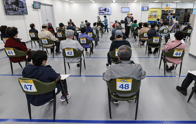 Senior citizens wait to receive COVID-19 jabs at a district office in eastern Seoul on April 9, 2021. (Yonhap)