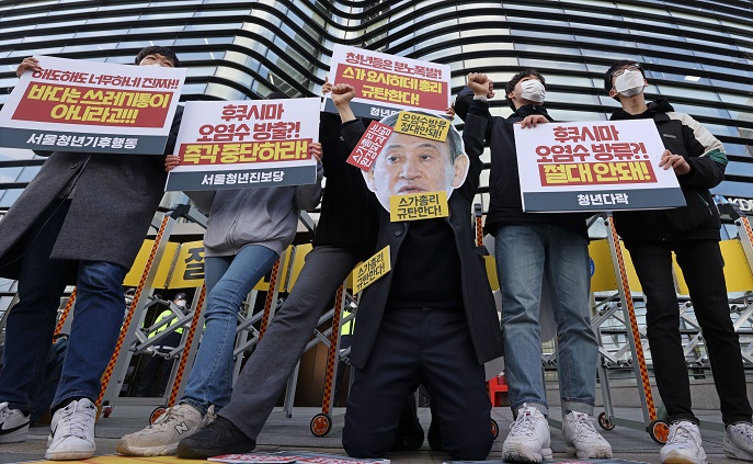 South Korean civic activists stage a protest against the Japanese government's decision to discharge radioactive water from the crippled Fukushima nuclear plant into the Pacific Ocean during a news conference in front of the Japanese Embassy in Seoul on April 13, 2021. (Yonhap)