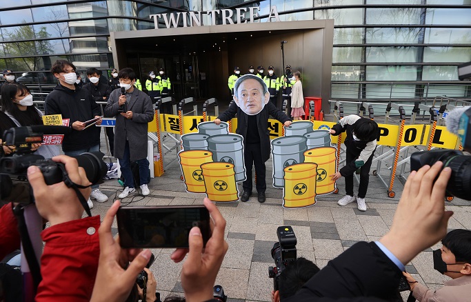 South Korean civic activists stage a protest against the Japanese government's decision to discharge radioactive water from the crippled Fukushima nuclear plant into the Pacific Ocean during a news conference in front of the Japanese Embassy in Seoul on April 13, 2021. (Yonhap)