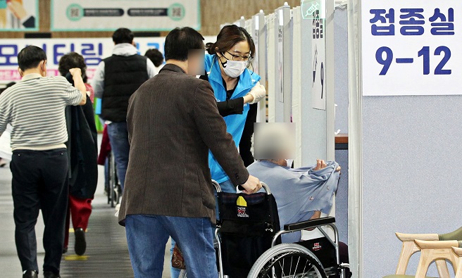 A senior in a wheelchair gets ready for inoculation with Pfizer's COVID-19 vaccine at a vaccination center in southern Seoul on April 17, 2021, in this photo provided by the Dongjak Ward Office.