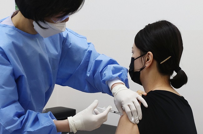 A flight attendant receives a COVID-19 vaccine shot at a hospital in Seoul on April 19, 2021. (Yonhap)