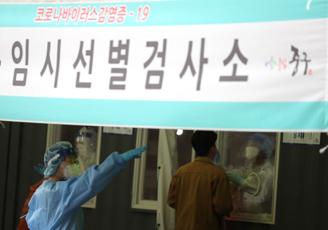 A medical worker conducts a coronavirus test at a makeshift clinic in front of Seoul Station on April 29, 2021. (Yonhap)
