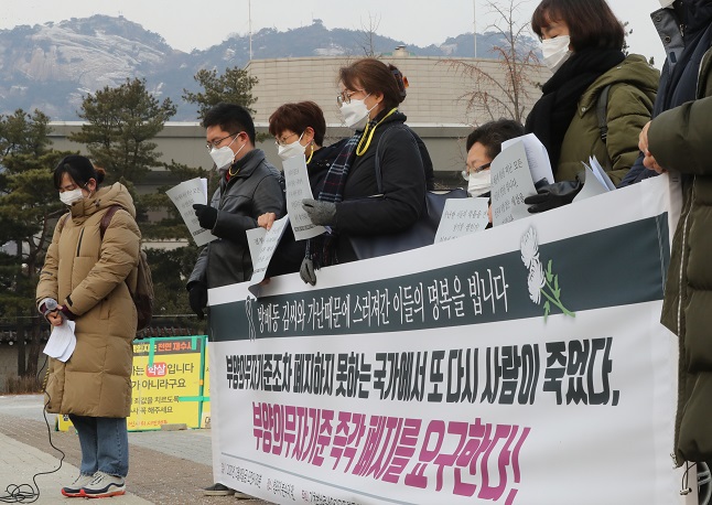In this file photo taken Dec. 18, 2020, civic group activists offer a silent tribute to a mother who died after struggling with economic hardships, leaving behind a mentally impaired son, in front of Cheong Wa Dae in Seoul. (Yonhap)