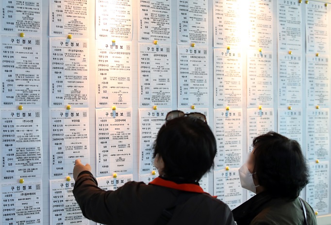 In the April 14, 2021, file photo, citizens look at job information at an employment arrangement center in Seoul. (Yonhap)