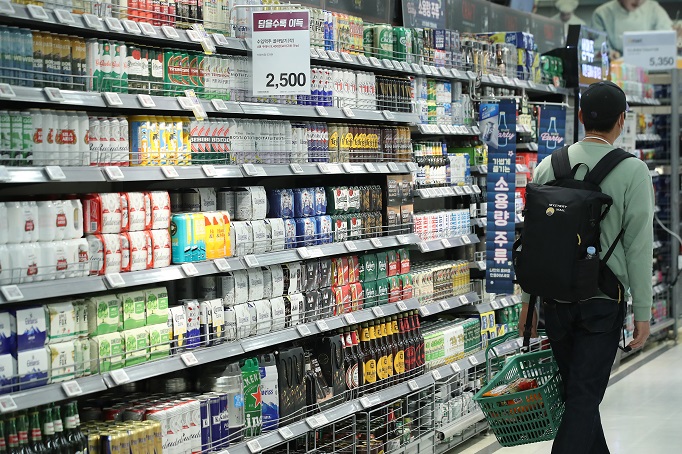A shopper passes by a beer section in a Seoul supermarket on April 19, 2021. (Yonhap)