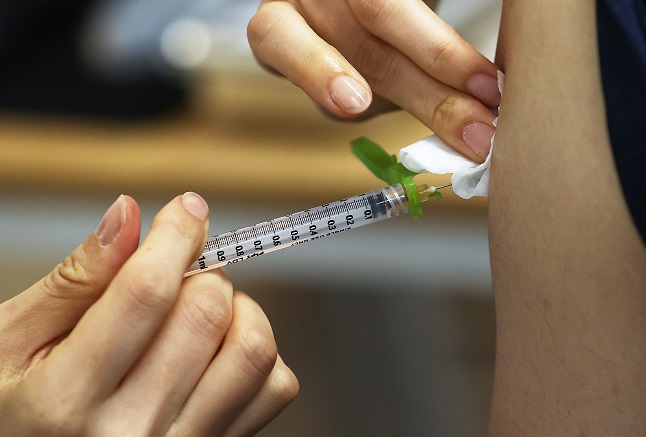 This file photo taken April 30, 2021, shows a medical worker administering a COVID-19 vaccine shot to a citizen at an inoculation center in Seoul. (Yonhap)
