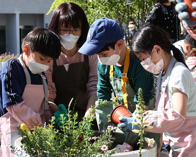 In this photo taken May 9, 2021, a family participates in an offline gardening event held in Manri-dong, central Seoul, amid the COVID-19 pandemic as part of the Seoul International Garden Show scheduled from May 14-20. (Yonhap)