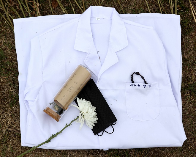 A doctor's gown stitched with the words "Dr. Son Jeong-min" is laid on the grass in Banpo Han River Park in Seoul on May 10, 2021, in remembrance of the medical school student who was found dead in the river on April 30. (Yonhap)
