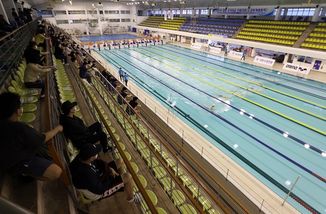 This photo taken on May 16, 2021, shows a small number of spectators watching a preliminary swimming match held at Jeju Stadium on Jeju Island to select members of the national team ahead of the Tokyo Olympics this year amid the COVID-19 pandemic. (Yonhap)