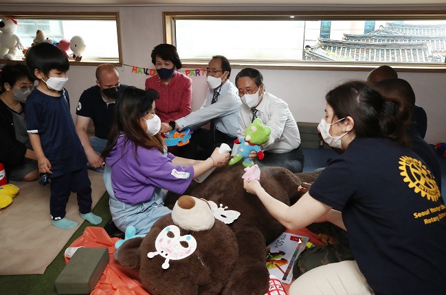This photo taken on May 16, 2021, shows Rotary International District 3650 Governor Yoo Jang-hee (3rd from R) and other participants disinfecting toys at a community center in Jongno, central Seoul, after delivering "COVID-19 hygiene gift sets" to 26 facilities for single mothers and 100 underprivileged households in Seoul. (Yonhap)