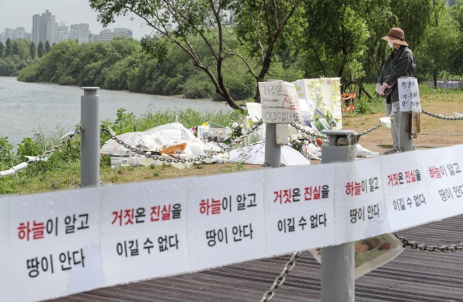 This May 25, 2021, photo shows posters lining an area of Banpo Han River Park in Seoul where Son Jeong-min was last seen. They read: "Heaven and Earth know" and "Lies cannot win over truth." (Yonhap)