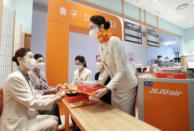 Jeju Air flight attendants serve in-flight meals at the airline's cafe in Hongdae area in western Seoul. (Yonhap)