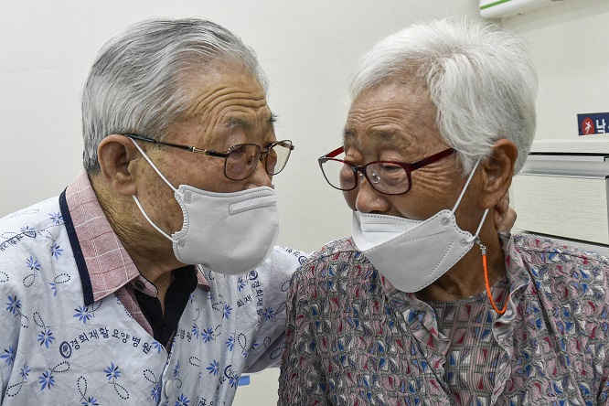 This pool photo shows Kim (R) and Lee, a married couple, meeting for the first time since the outbreak of COVID-19 at a long-term care hospital in Ansan, Gyeonggi Province, where Lee is a patient, on June 1, 2021. (Yonhap)