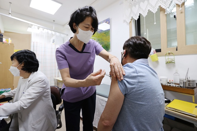 A health worker gives a COVID-19 vaccine shot to a citizen in Seoul on June 7, 2021. (Yonhap)