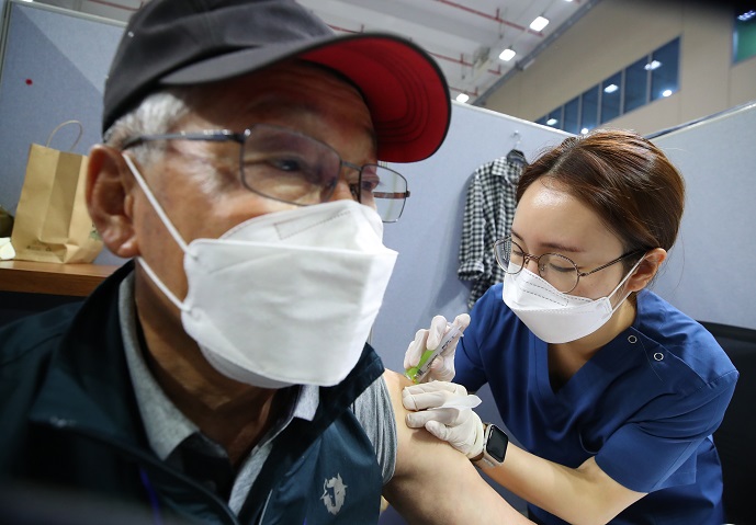 A medical worker gives a COVID-19 vaccine jab to an elderly person at a vaccination center in southern Seoul on June 8, 2021. (Yonhap)