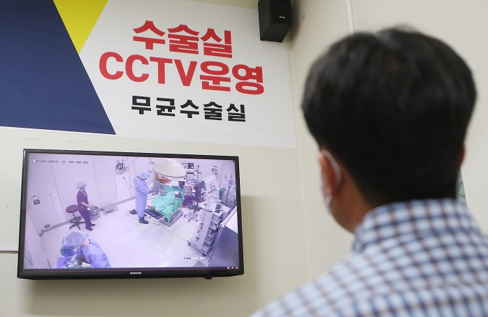 A man watches real-time footage of an operating room via closed-circuit (CC) TV at a hospital in Incheon, 40 kilometers west of Seoul, on June 11, 2021. (Yonhap)
