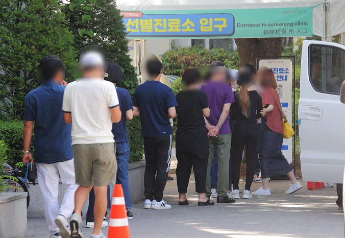People stand in line to get tested for COVID-19 at a health clinic in southeastern Seoul on June 12, 2021. (Yonhap)