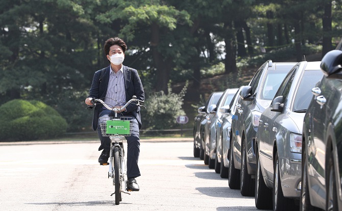 Lee Jun-seok, chairman of the People Power Party, rides a bike to the National Assembly in Seoul on June 13, 2021. (Yonhap)
