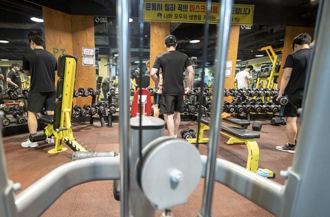 People work out at a gym in Seoul's Mapo Ward on June 13, 2021. The ward office launched a pilot project of extending business hours of indoor gyms until midnight. (Yonhap)