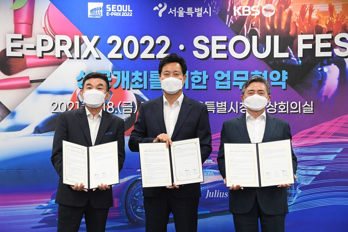 Seoul Mayor Oh Se-hoon (C) poses with the heads of Formula E Korea and public broadcaster KBS at his office on June 18, 2021, after signing a three-party cooperation agreement for the success of Seoul E-Prix 2022, in this photo provided by Oh's government.
