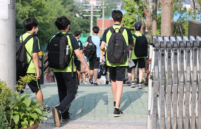 Students arrive at a middle school in Seoul on June 21, 2021, as health authorities are set to apply eased social distancing rules next month. (Yonhap)