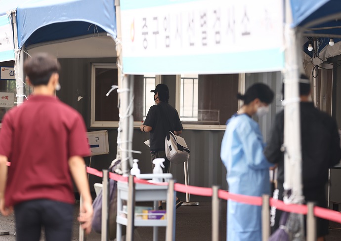 Citizens undergo a COVID-19 test at a temporary test center near Seoul Station on June 26, 2021, as the country's daily virus tally surpasses 600 for the fourth consecutive day. (Yonhap)