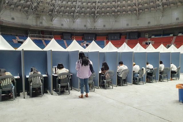 Visitors at "Beautiful Mint Life 2021," an outdoor music festival, use self-test kits to test for the new coronavirus ahead of entering the concert venue at Olympic Park in southeastern Seoul on June 27, 2021. (Yonhap)