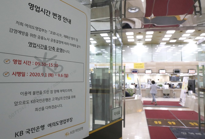 A notice informs people that business hours will be reduced by one hour at a bank in Seoul on July 9, 2021. (Yonhap)