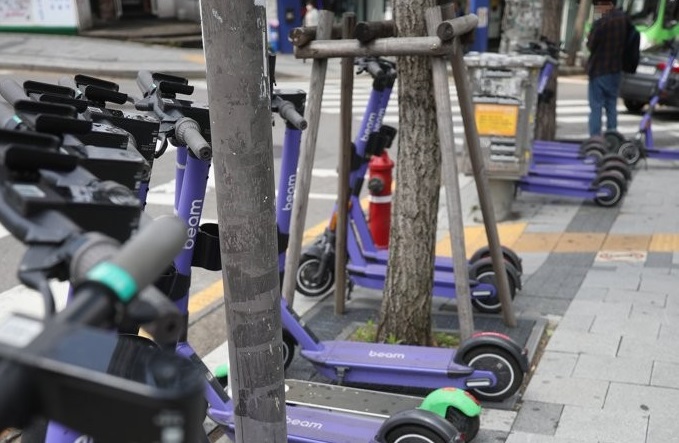 Electric kickbords remain idle on a road in Seoul on May 25, 2021. The use of kickbords has been on a sharp decrease since the amended road traffic law allowing only people over age 16 with licenses and safety helmets to drive personal mobility vehicles took effect on May 13. (Yonhap)