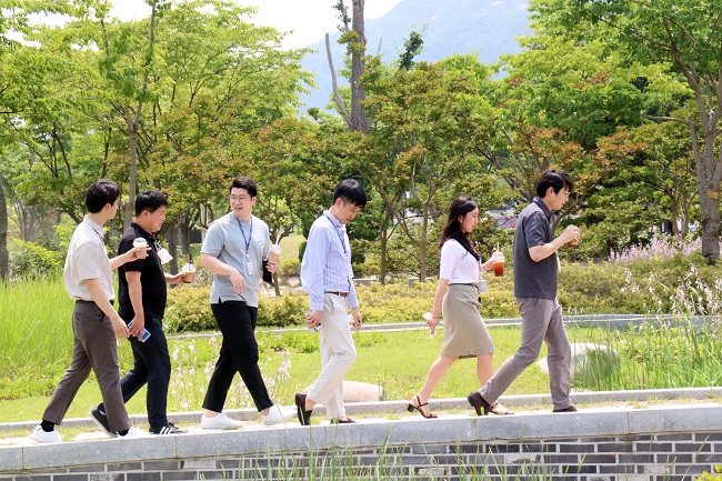 Vaccinated civil servants who belong to a fire service department walk without wearing masks in a public park in Hongseong, central South Korea, on July 1, 2021. (Yonhap)