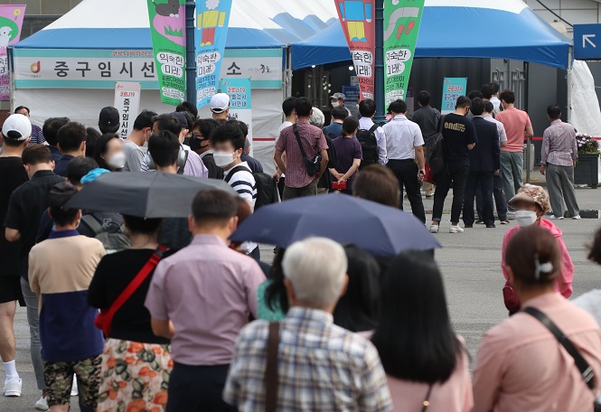 People stand in line to take coronavirus tests at a screening clinic in front of Seoul Station on July 7, 2021. (Yonhap)