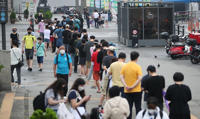 Citizens wait in line to receive COVID-19 tests on July 11, 2021, at a makeshift testing center set up in front of Seoul Station in central Seoul as new cases rose above 1,300 for the third straight day. (Yonhap)
