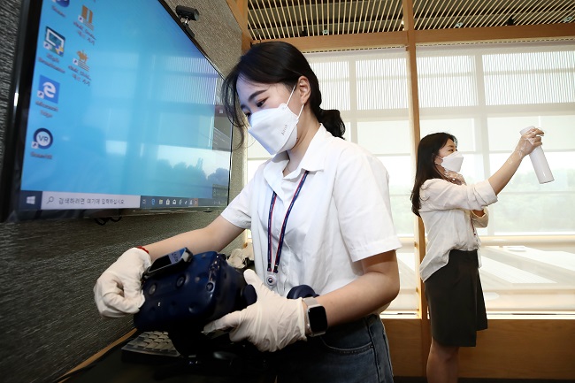 Health workers disinfect virtual reality headsets at the National Museum of Korea in central Seoul on July 12, 2021. (Yonhap)