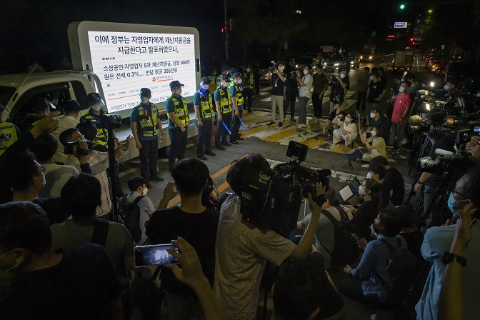Police and the press are gathered at a protest by small business owners against the government's COVID-19 restrictions near Yeouido Park, western Seoul, on July 14, 2021. (Yonhap)