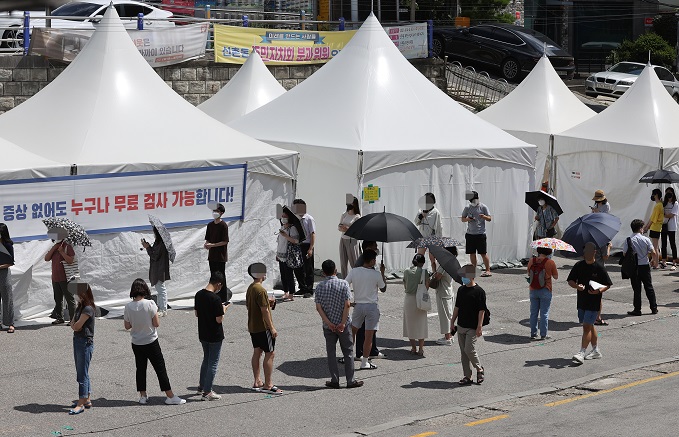 People wait in line to get tested for COVID-19 at a temporary testing center installed at a parking lot outside Sinchon Station in western Seoul on July 15, 2021. (Yonhap)