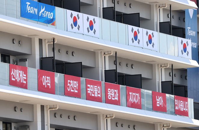 South Korean national flags and banners with the words, "I still have support from 50 million Korean people," are hung on balconies at the athletes' village for the Tokyo Olympics in Tokyo on July 16, 2021. (Yonhap)