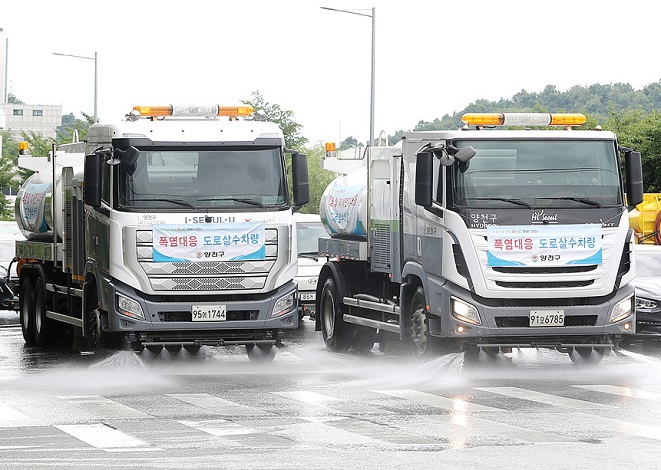 This photo provided by the Yangcheon Ward office in western Seoul on July 20, 2021, shows water sprinkler trucks in operation amid an extended heat wave across the nation.