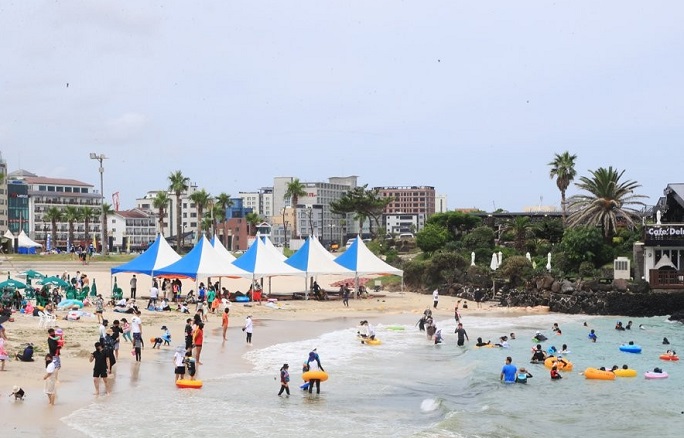 Hamdeok Beach on the southern resort island of Jeju bustles with vacationers on July 24, 2021. (Yonhap)