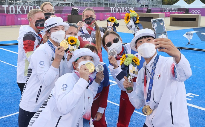 South Korean archer An San (R) takes a selfie with her teammates and other medalists from the women's team event at the Tokyo Olympics at Yumenoshima Park Archery Field in Tokyo on July 25, 2021. South Korea won the gold medal over the Russian Olympic Committee. (Yonhap)