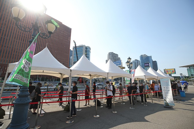 People stand in line to take coronavirus tests at a screening clinic in front of Seoul Station in Seoul on July 27, 2021. (Yonhap)
