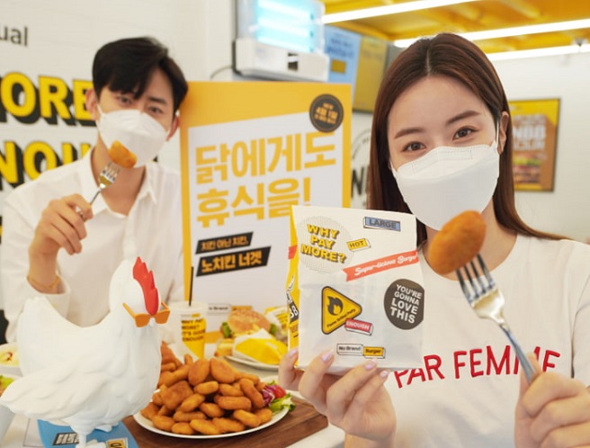 This March 31, 2021, file photo provided by Shinsegae Food shows models promoting "no chicken nuggets" at an outlet of the No Brand Burger franchise in central Seoul. 